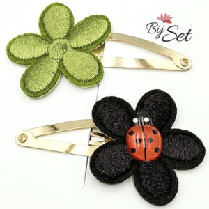 groene en zwarte bloem op haarspeldje met een lieveheersbeestje